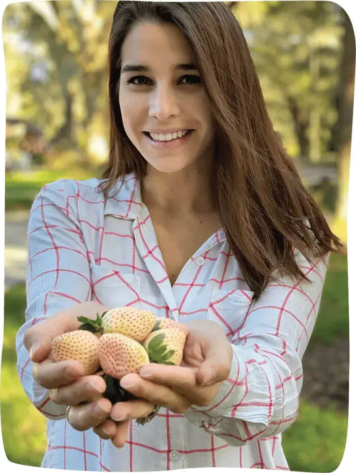 A beautiful lady with hands full of Pineberry