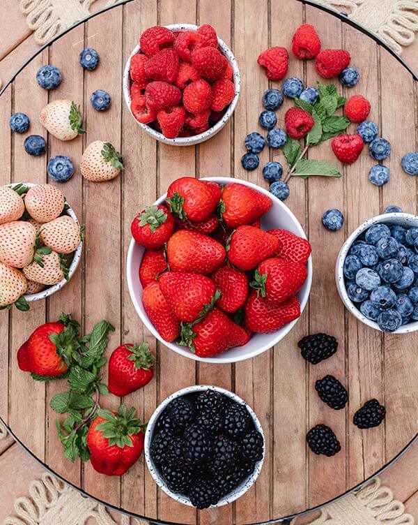 Cups of assorted berries in a wooden tray for Berry Lovers